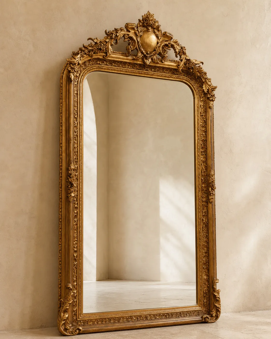 Large ornate antique-gold mirror against a warm plaster wall